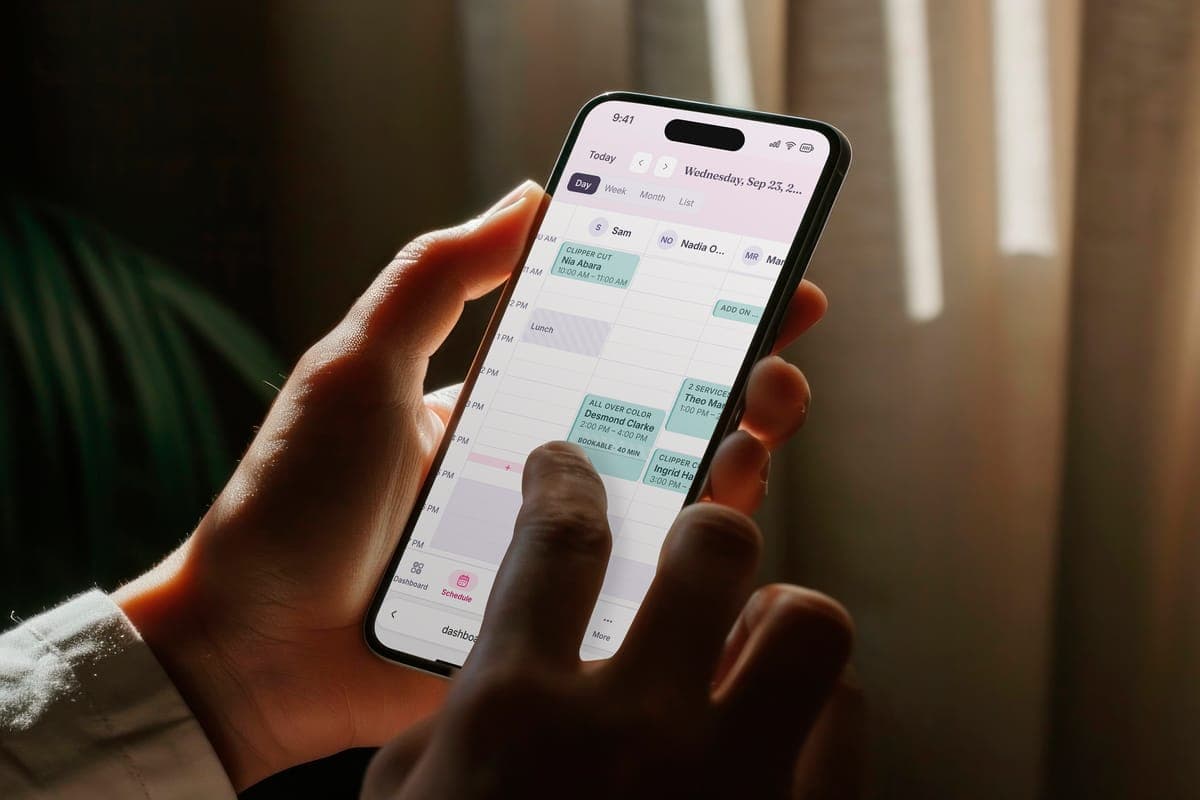 A phone held in one hand showing the day's schedule in Inchair.
